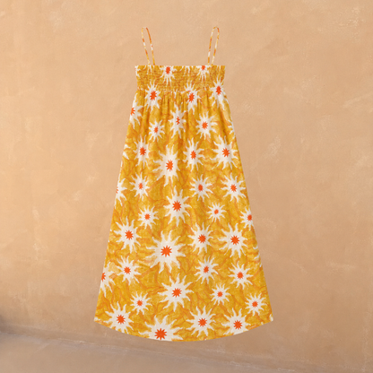 Girl's yellow cotton maxi sun dress with an orange sun print, shirred bodice and thin straps.