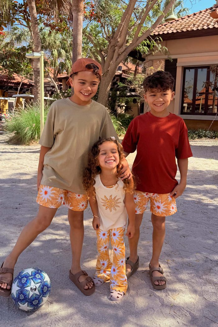 Girl's Yellow Sun Cotton Set with a cream sequin vest and soleil sun print trousers on vacation.