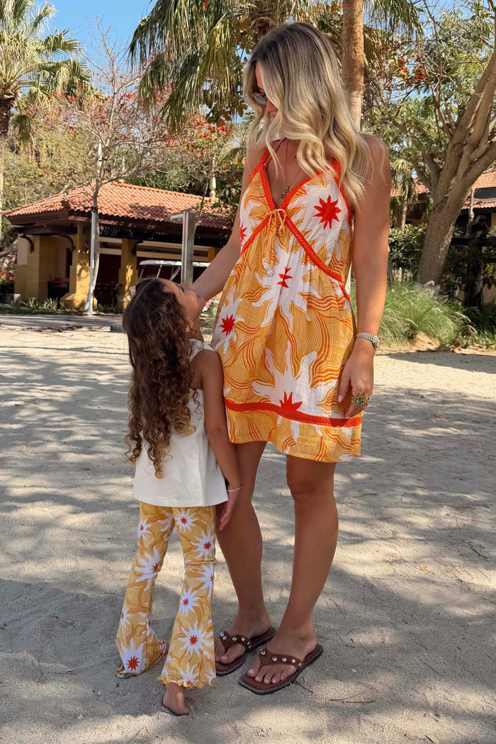 Girl's Yellow Sun Cotton Set featuring flared trousers and iconic soleil motifs on vacation.