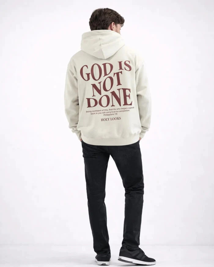 Person wearing a hoodie with 'God is Not Done' text on the back, standing against a white background