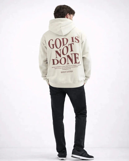 Person wearing a hoodie with 'God is Not Done' text on the back, standing against a white background