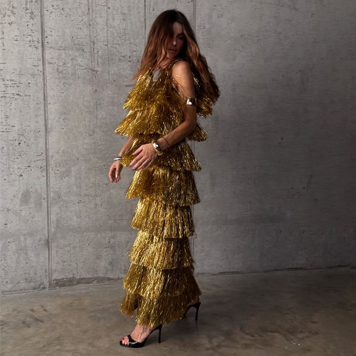 Gold Fringe Dress with tiered foil tassels and a sleeveless silhouette, styled for a party against a concrete wall.