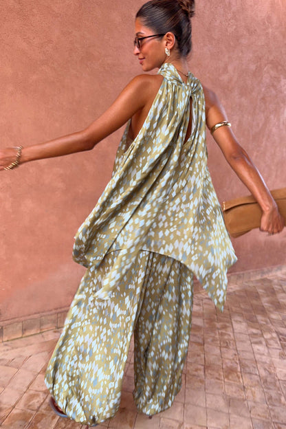 Olive green diamond print halter top with a draped back and asymmetric hem, styled with matching co-ord trousers.