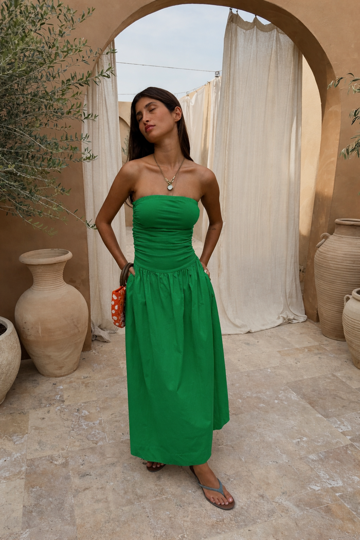 Green Lola Mid-axi Dress featuring a ruched bodice and breathable cotton skirt, styled strapless for summer vacation.