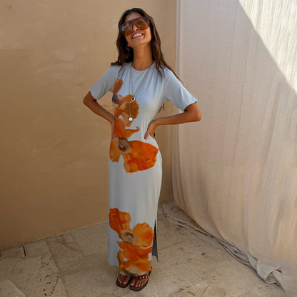 Ice Blue Floral Rib Dress with a bold orange floral print, short sleeves and a side slit on a model.