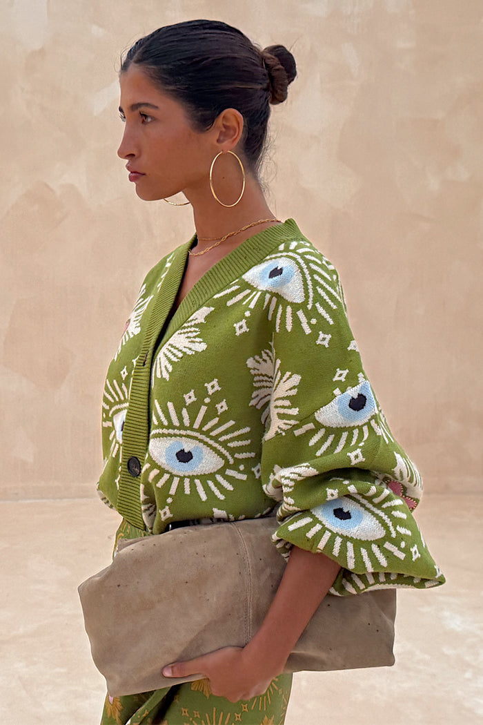 Khaki Eye Cardigan in a soft green knit with iconic eye and heart motifs, shown from a side profile.