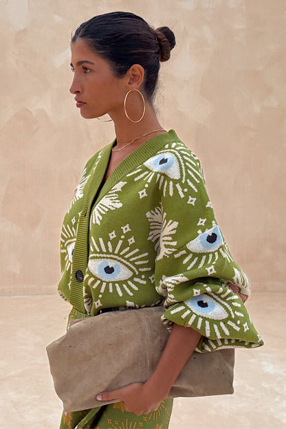 Khaki Eye Cardigan in a soft green knit with iconic eye and heart motifs, shown from a side profile.