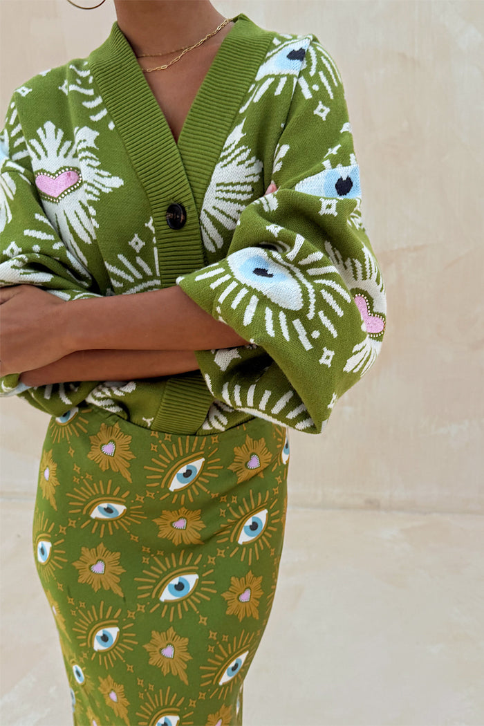 Khaki knit cardigan featuring iconic eye and heart motifs, paired with a matching printed Dorris skirt.