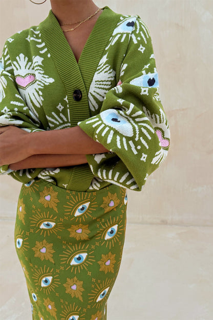 Khaki knit cardigan featuring iconic eye and heart motifs, paired with a matching printed Dorris skirt.