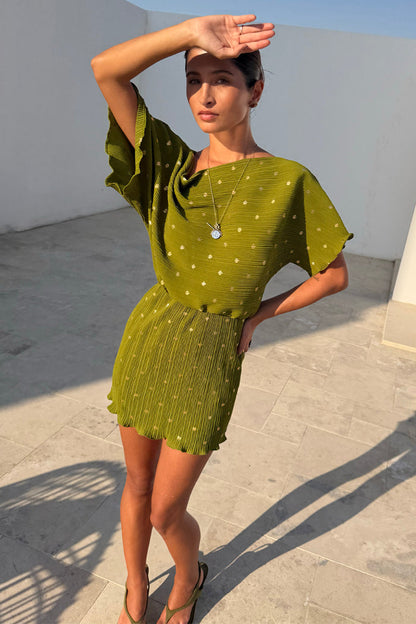 Khaki Mini Plisse Tilly Dress featuring a gold fleck print and wide sleeves on a model in a sunny outdoor setting.