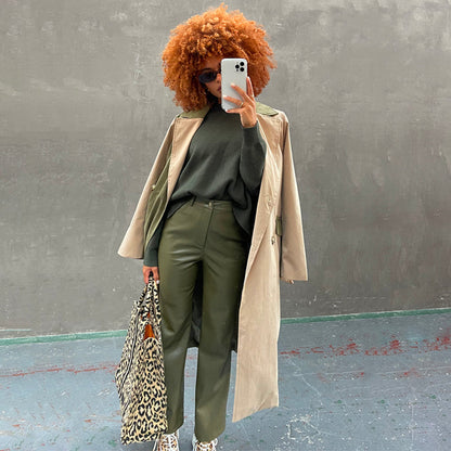 Khaki Vegan Leather Trousers styled with a green knit, beige trench coat, and leopard print tote bag.