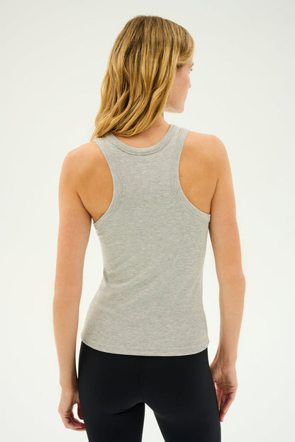 Person wearing the SPLITS59 Kiki Rib Tank Full Length in Heather Grey and black pants, standing with their back towards the camera, as if ready for some intense gym workouts.