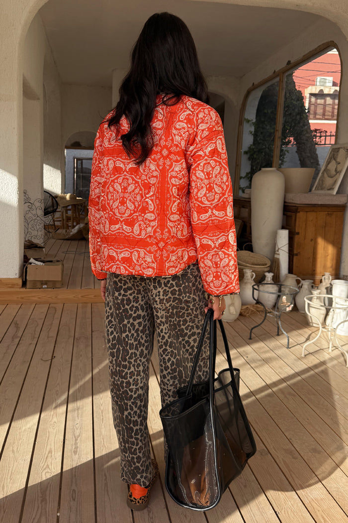 Leopard Barrel Jeans in iconic animal print with a relaxed barrel leg, styled with a red paisley quilted jacket.