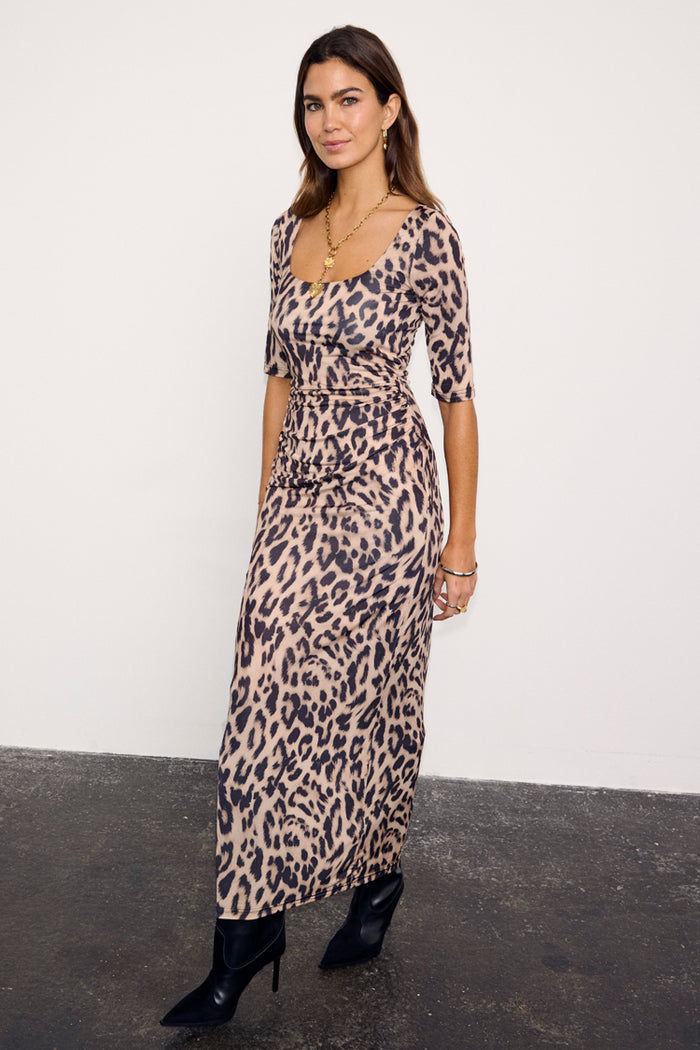 Leopard Iris Dress with ruched waist detail and elbow sleeves, styled with black pointed-toe boots.