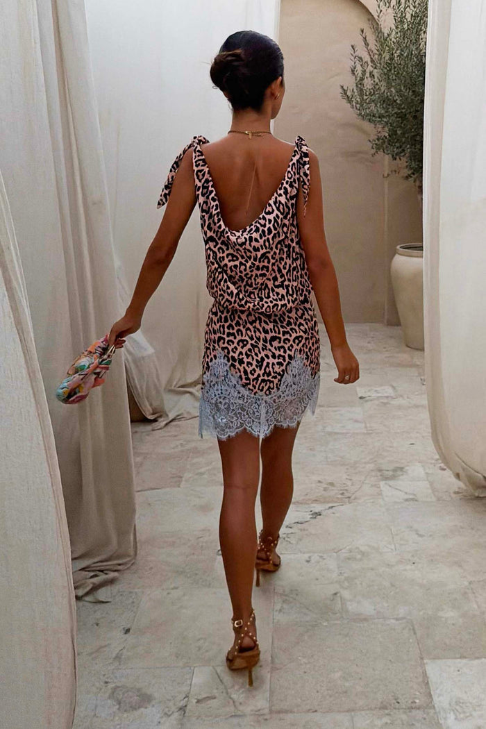 Leopard Leila Mini Dress with adjustable tie shoulder straps and a contrast lace trim hem, shown from the back.