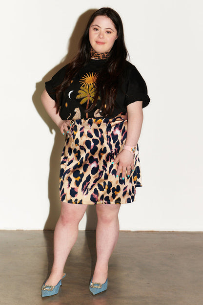 Iconic Leopard Mini Jaspre wrap skirt styled with a black graphic tee and blue pointed-toe heels.