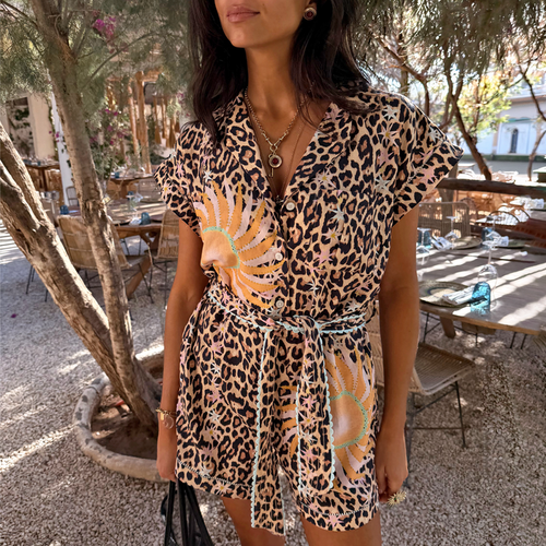 Leopard and soleil print playsuit featuring turquoise trim, a button-through front and adjustable tie waist on a model.