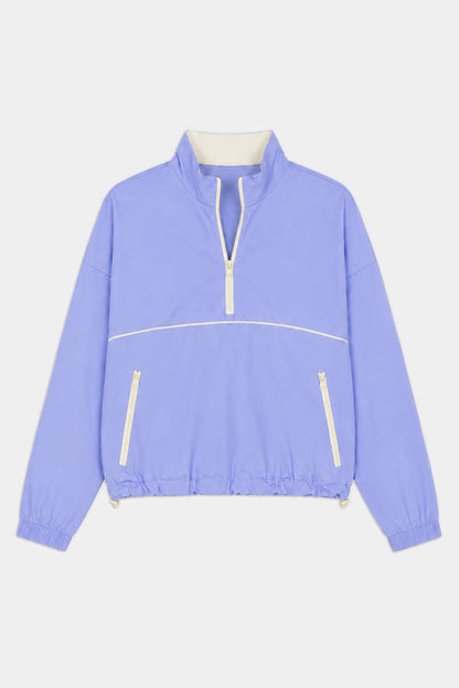 The SPLITS59 Lyle Woven Nylon Pullover in Purple Haze/Creme features a soft nylon-spandex blend, white zipper accents, high collar, elastic cuffs and hem, and two front zippered pockets.