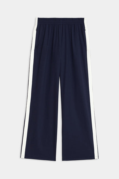 Maxie Rigor Track Pant by SPLITS59, featuring a navy color with an elastic waistband and white side stripes, showcased on a plain background.