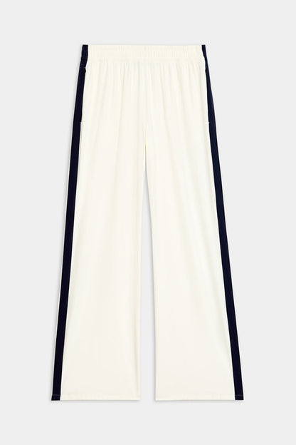 The Maxie Rigor Track Pant in white and indigo from SPLITS59, made from rigor fabric with an elastic waistband, is shown on a plain background.