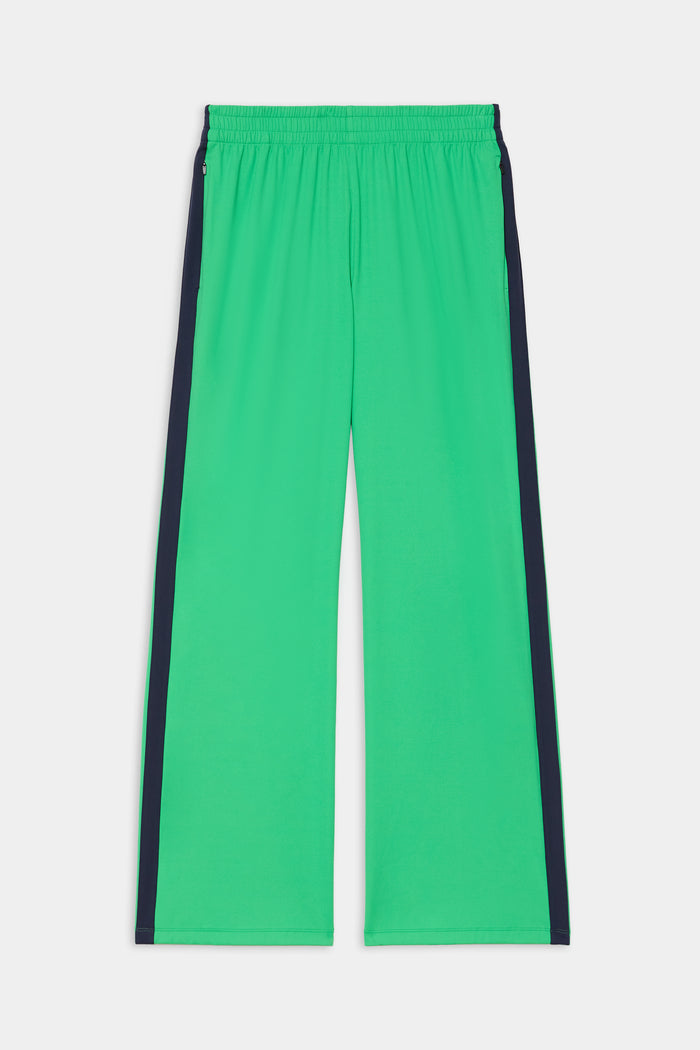 The SPLITS59 Maxie Rigor Trackpant in Grass/Indigo features a bright green wide-leg design, elastic waistband, and dark indigo side stripes, shown laid flat on a white background.