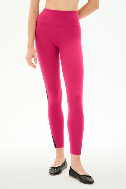 Model wears SPLITS59 Miles High Waist Rigor 7/8 leggings in Sangria/Black with black ballet flats, standing against a plain white background.