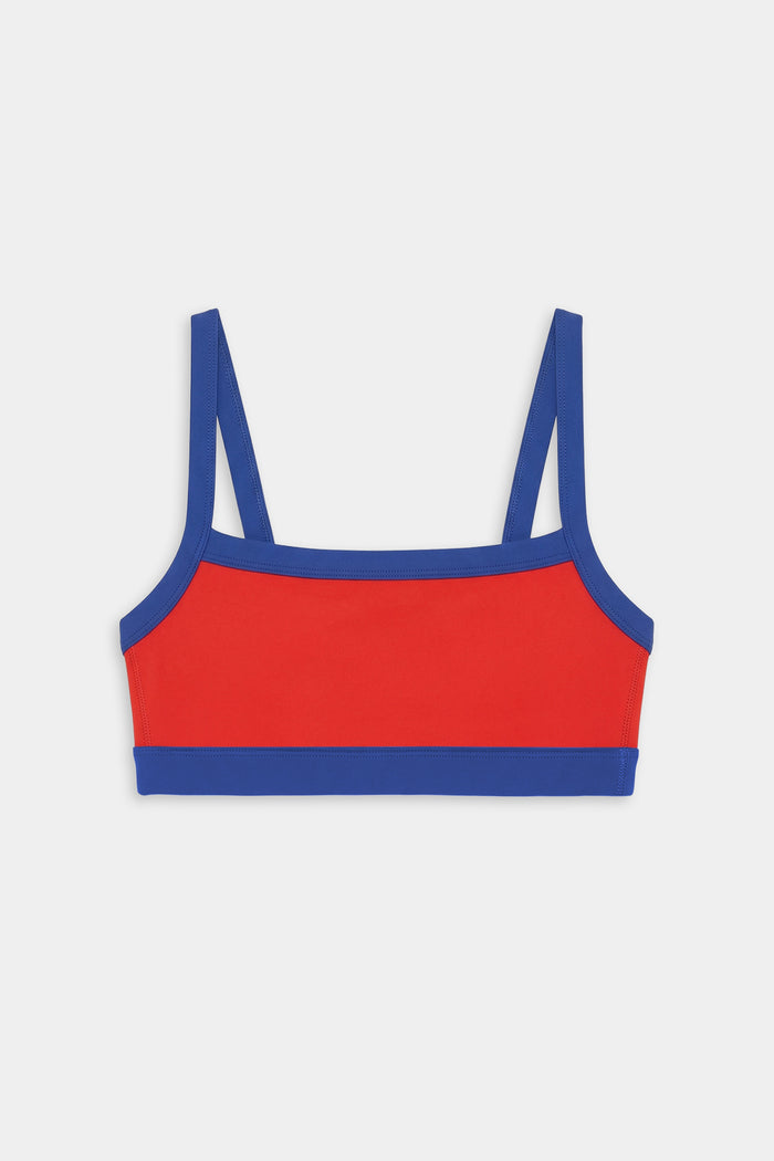 The SPLITS59 Monah Rigor Bra in Lotus Red/Cobalt features blue straps and trim, shown against a plain white background.