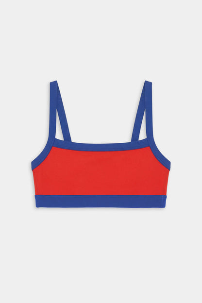 The SPLITS59 Monah Rigor Bra in Lotus Red/Cobalt features blue straps and trim, shown against a plain white background.