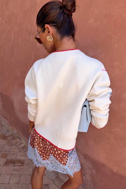 Morocco Charms Cheryl Cardigan in cream with red trim, a designed in London knit shown from the back.