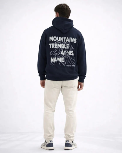 Person wearing a navy hoodie with text on the back, standing against a white background