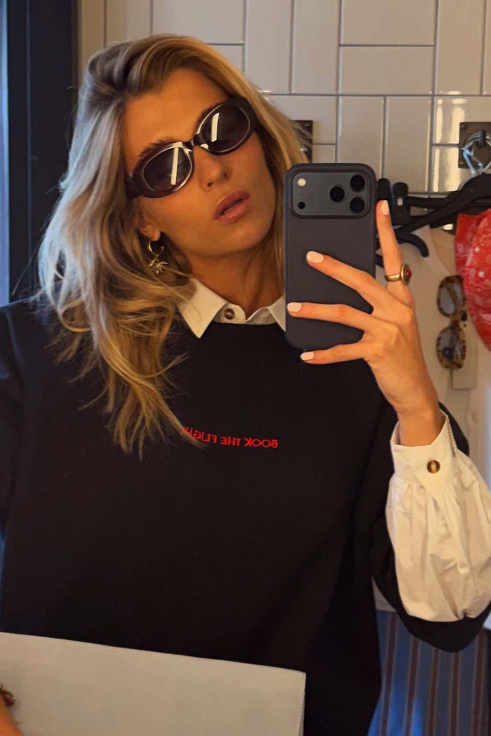 Navy Book The Flight Jumper with red text, layered over a white collared shirt in a mirror selfie.