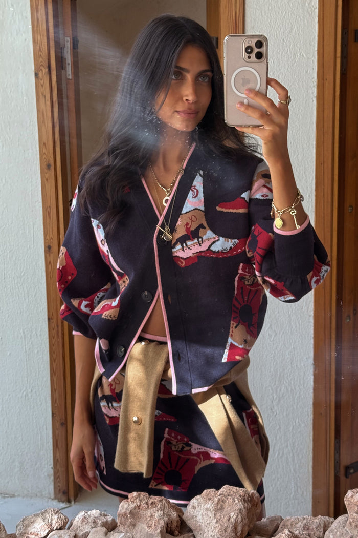 Navy Cowboy Boots Cardigan with red cowgirl motifs and pink trims, styled with a matching skirt in a mirror selfie.