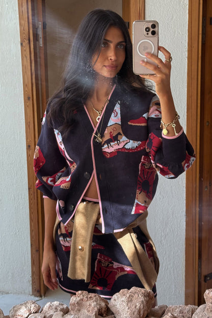 Navy Cowboy Boots Cardigan with red cowgirl motifs and pink trims, styled with a matching skirt in a mirror selfie.