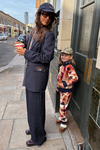 Navy Pinstripe Arden Trousers and matching blazer styled for a smart-casual London look on a city street.