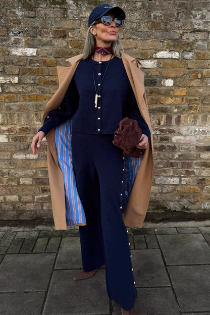 Navy Studded Cardigan with silver studs, styled as a co-ord with matching trousers and a tan trench coat.