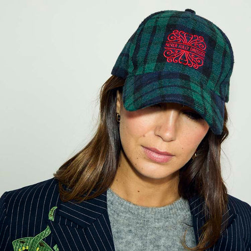 Navy Tartan NFD Cap in a blue and green cotton check with a red embroidered logo, styled on a model in a pinstripe blazer.