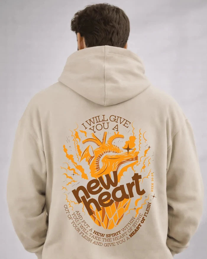 Person wearing a beige hoodie with an orange and brown graphic and text on the back against a gray background
