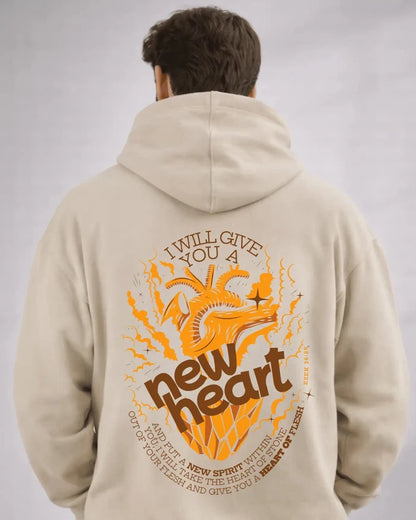 Person wearing a beige hoodie with an orange and brown graphic and text on the back against a gray background