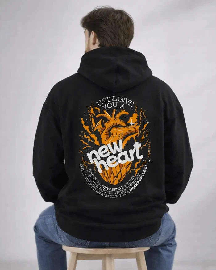 Person wearing a black hoodie with a graphic design on the back, sitting on a stool against a plain background.
