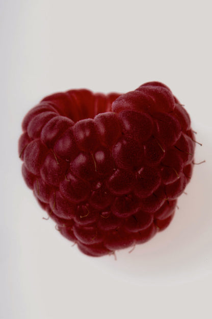 Vibrant dark red raspberry close-up, representing the top scent note of the NFD Eau De Parfum Candle 002.