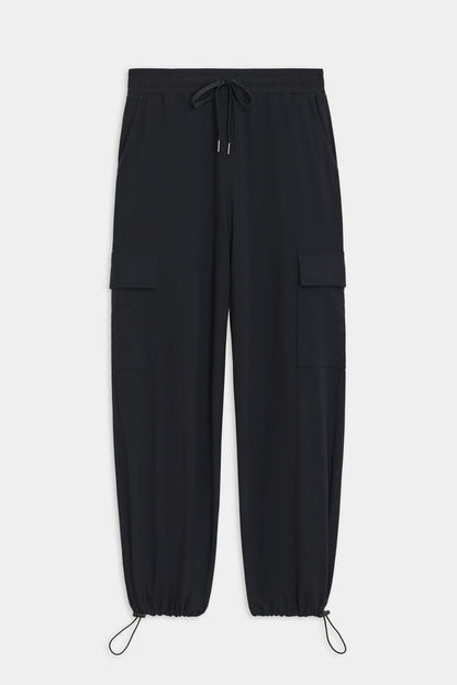 The Nico Airweight Cargo Pant by SPLITS59, in black, features a relaxed fit with side pockets and elastic cuffs. Made of lightweight Airweight fabric, these pants offer ultimate comfort and style for everyday wear, displayed flat on a white background.