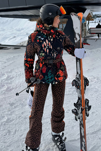 Night Garden Ski Jacket featuring iconic leopard and poppy motifs, belted and worn on a snowy mountain slope.