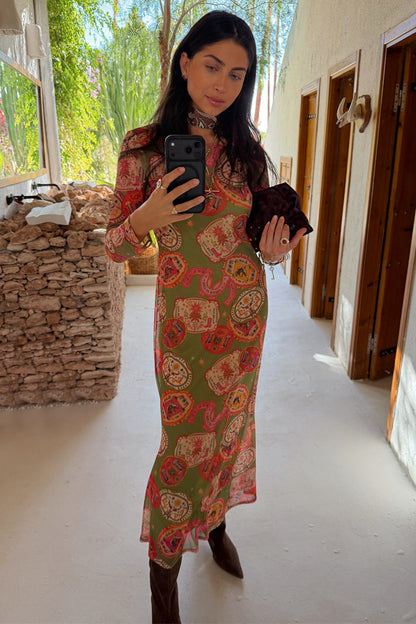 Olive Buckles Mesh Dress with western horseshoe motifs and long sleeves, styled with brown boots in a mirror selfie.