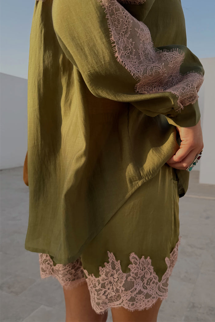 Olive green satin shorts featuring a contrast pink lace hem, styled with the matching lace-trimmed shirt.