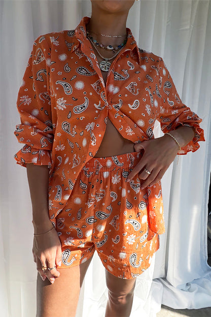 Model wearing the Orange Leopard Elissa Short and matching shirt in a bold paisley and palm print.