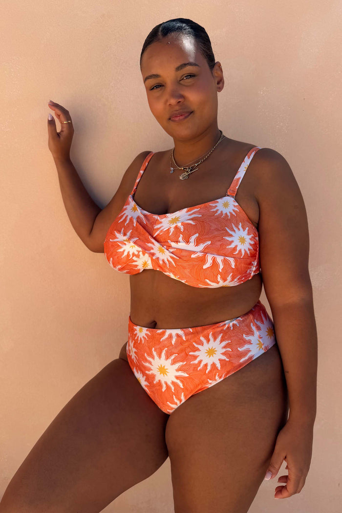 Orange Sun Bandeau Bikini Top with white sun motifs and a twist front for inclusive sizing.