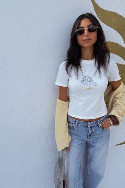 White Oyster Baby T Shirt with a fine line oyster and lemon print, paired with light blue denim jeans.