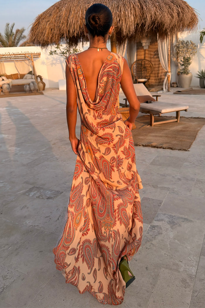 Peach Paisley Ava Dress featuring a low cowl back and bias-cut silhouette, captured in a vacation setting.