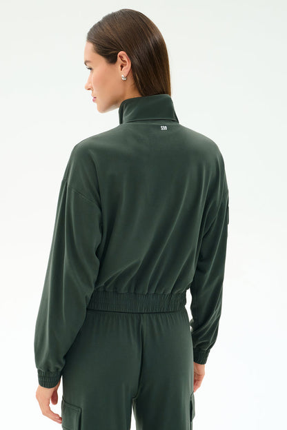 A person seen from behind, head turned left, wears the Peaches Airweight Cargo Jacket - Military by SPLITS59.