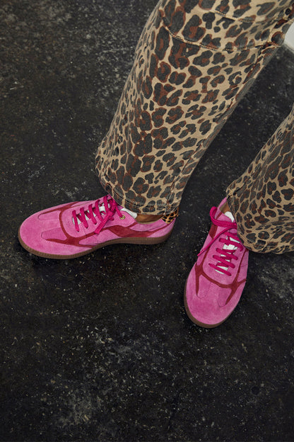 Pink and Red Leather Trainers in a sleek silhouette, paired with leopard print trousers for a street style London look.